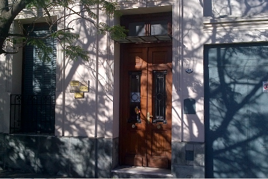 Puerta de madera de entrada al consultorio, con las chapas de los profesionales