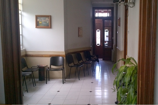 Pasillo con sillas de espera que va hacia la puerta de calle