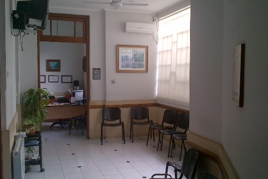 Sala de espera con sillas y recepción al fondo